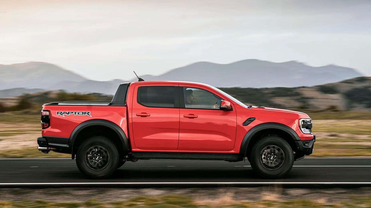 Full side view of a red pickup with both wheels and all body panels visible